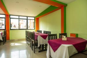 una sala da pranzo con tavoli e sedie con pareti colorate di Kathmandu Peace Hotel a Kathmandu