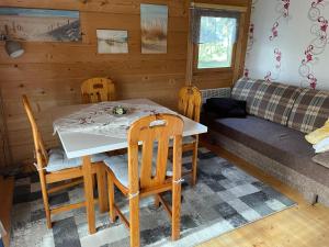 een eetkamer met een tafel en stoelen en een bank bij Ferienhaus am Damwildgatter in Neu Kosenow