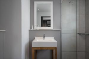 y baño con lavabo blanco y espejo. en Protea Hotel by Marriott Cape Town Sea Point, en Ciudad del Cabo