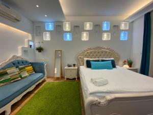 ein Schlafzimmer mit einem Bett, einem Sofa und Spiegeln in der Unterkunft 恆春洋蔥風格旅居 onion in in Altstadt von Hengchun