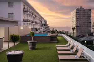 a balcony of a building with chairs and a pool at Protea Hotel by Marriott Cape Town Sea Point in Cape Town