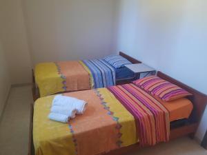 a group of four beds with different colored blankets at La Casa del Mugnaio in Rotonda