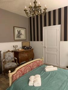 a bedroom with a green bed with two towels on it at Chambre La Princière in Lorris
