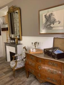 a room with a dresser and a mirror and a chair at Chambre La Princière in Lorris