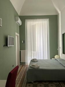 a bedroom with a bed and a large window at La Dimora dell' Architetto in Gravina in Puglia