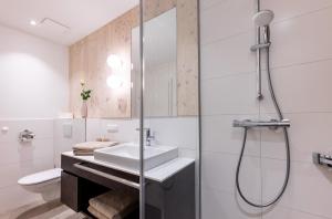 a bathroom with a sink and a shower at wohn.genuss app traumhaus in Schladming +43 photos