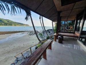 eine Veranda eines Resorts mit Blick auf den Strand in der Unterkunft Family House in Ko Por