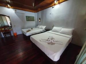 um quarto com 2 camas com lençóis brancos e decorações em Family House em Ko Por