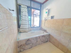 a bathroom with a bath tub and a window at Family House in Ko Por