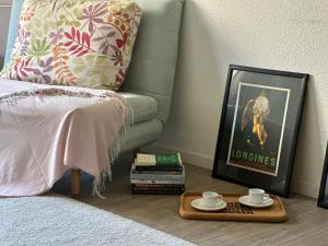 a bed with a tray with two cups and a picture at Spacious apartment in Zurich