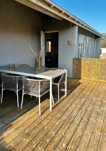 Skøn villalejlighed i Skagen med terrasse og tæt på centrum في سكاغن: طاولة وكراسي على سطح خشبي