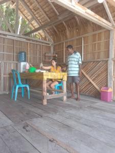 a man and a woman sitting at a table in a barn at Amfriwen Homestay in Yennanas Besir