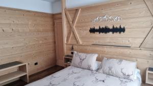 コルティーナ・ダンペッツォにあるホテル ヴィラ ガイアの木製の壁のベッドルーム1室(ベッド1台付)