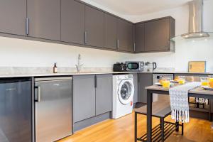 a kitchen with stainless steel cabinets and a washer and dryer at New Deluxe4beds 2bath Apartment Near Highstreet in Southampton