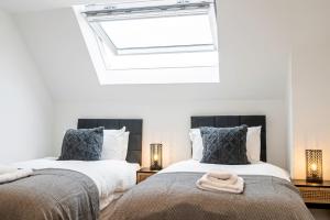two beds in a bedroom with a skylight at New Deluxe4beds 2bath Apartment Near Highstreet in Southampton