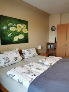 a bedroom with two beds and a painting on the wall at Gästehaus Schu in Marpingen