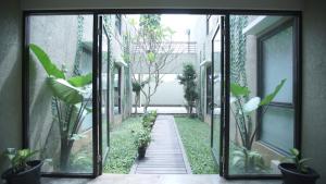 an open door to a courtyard with plants at The Heritage Karawaci in Binong