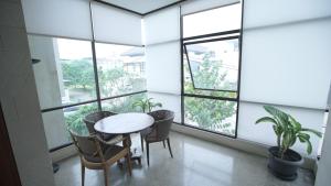a room with a table and chairs and windows at The Heritage Karawaci in Binong