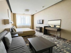 a hotel room with a couch and a bed and a desk at 12th Floor Apartments in Odesa