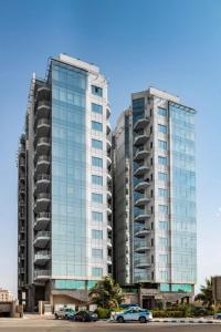 two tall buildings with cars parked in a parking lot at Obhur Residence 2 in Obhor