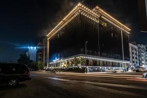 a large building with lights on a street at night at Paradise Inn Jeddah Hotel in Jeddah