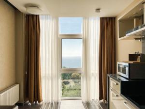 um quarto com uma grande janela com vista para o oceano em 12th Floor Apartments em Odessa
