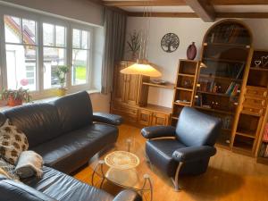 een woonkamer met een leren bank en 2 stoelen bij Traumhaft große Ferienwohnung nähe Attersee in Sankt Georgen im Attergau