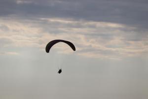 a person flying a parachute in the sky at Hobbit House Bir in Bīr