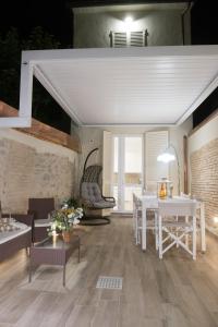 - un salon avec une table et des chaises blanches dans l'établissement 70mt dal mare, à Viareggio