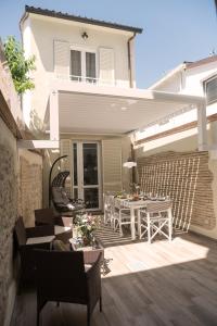 une terrasse avec une table et des chaises devant une maison dans l'établissement 70mt dal mare, à Viareggio