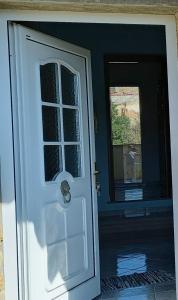 - une porte blanche avec une fenêtre dans la chambre dans l'établissement Casa Bia Mara IUN SU172600, à Villanovaforru