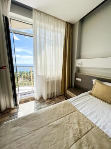 um quarto com uma cama grande e uma janela grande em 12th Floor Apartments em Odessa