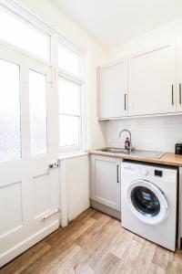 a white laundry room with a washing machine in it at STUNNING 5 bed House in Clapham - FREE WIFI! in London