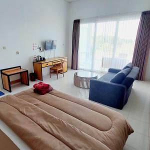 a large bed in a living room with a blue couch at Garden House Jepara in Jepara