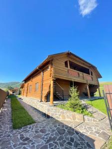 a large wooden house with a stone path in front of it at Chalet Borzhava in Huklyvyy