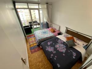 een kleine slaapkamer met 2 bedden en een balkon bij Chambre chez l’habitant près de Tour Eiffel in Parijs