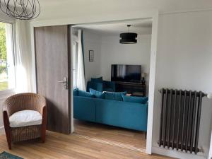 a living room with a blue couch and a chair at GÎTES Maisons de Champagnes in Reims