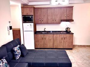 a living room with a couch and a kitchen at Royal Luxury Apartments & Studios 2 in Amman