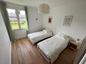 a bedroom with two beds and a window at GÎTES Maisons de Champagnes in Reims