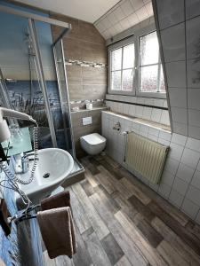uma casa de banho com um lavatório e um WC em Hotel Garni Nolting em Esens