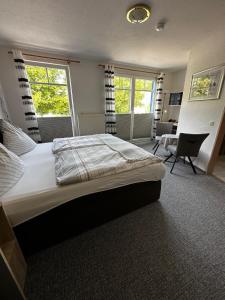 um quarto com uma cama grande e uma cadeira em Hotel Garni Nolting em Esens
