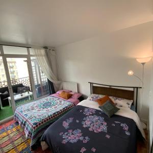 een slaapkamer met 2 bedden en een balkon bij Chambre chez l’habitant près de Tour Eiffel in Parijs