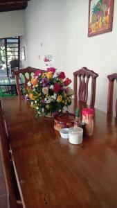 een vaas met bloemen bovenop een houten tafel bij Casa Riverstone in León