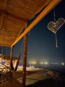 eine Hängematte am Strand in der Nacht in der Unterkunft Alwaha Camp in Nuweiba