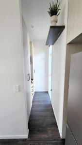 a hallway with white walls and a plant on the ceiling at Plush 3 bedroom property in Hobsonville in Auckland