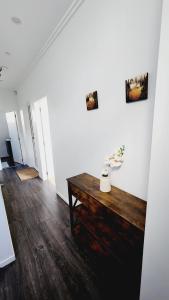 a room with a wooden table and white walls at Plush 3 bedroom property in Hobsonville in Auckland