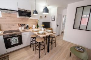 a kitchen with a table and stools in a room at T2 cosy et climatisé au cœur de la ville - La Golondrina in Martigues +39 photos