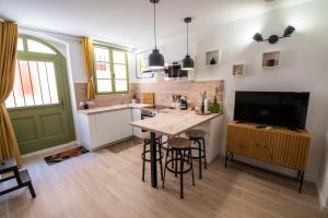 cocina con mesa de madera y TV en T2 cosy et climatisé au cœur de la ville - La Golondrina, en Martigues