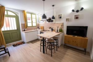 a kitchen with a wooden table and a television at T2 cosy et climatisé au cœur de la ville - La Golondrina in Martigues