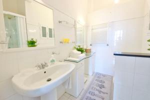 a white bathroom with a sink and a mirror at IL FARO by KlabHouse in Santa Margherita Ligure
